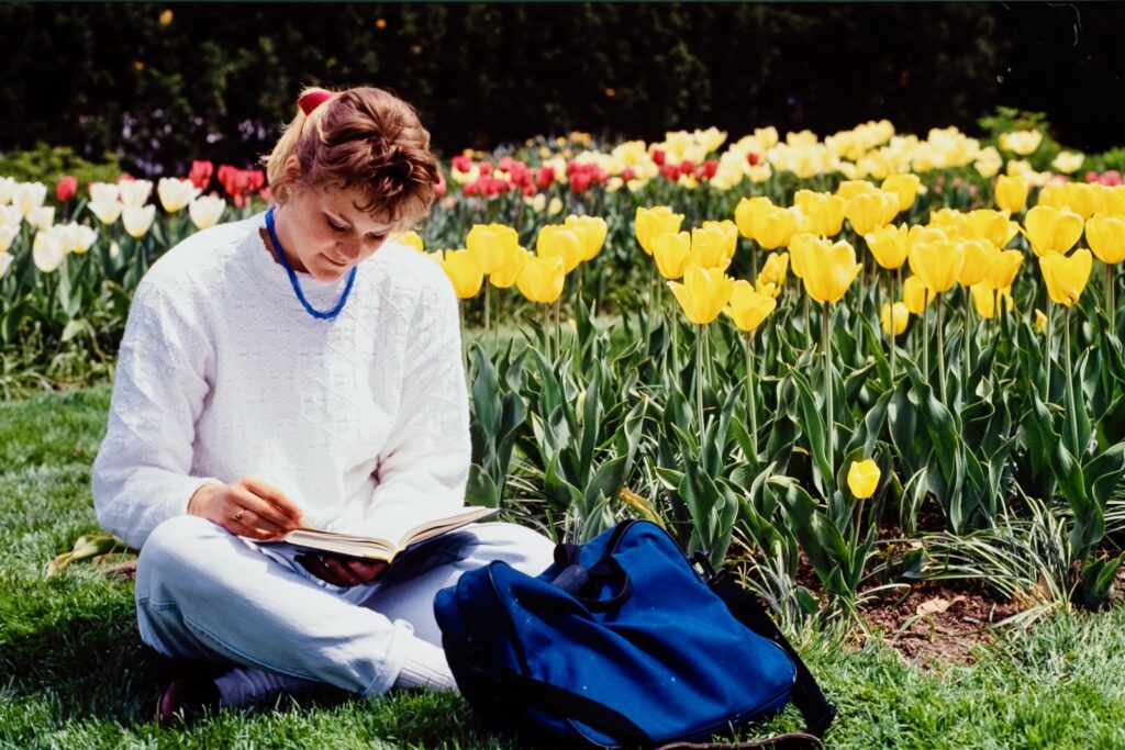 a student studies amid rows of flowering tulips in spring 1991
