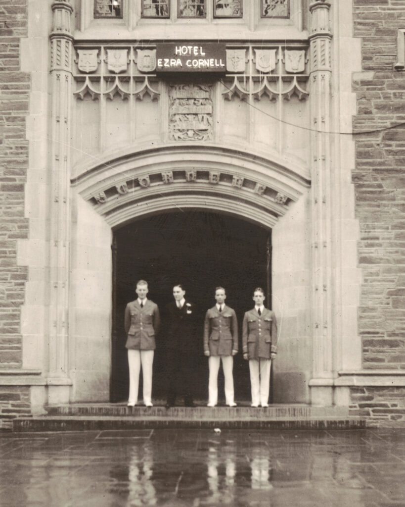 Uniformed students stand at the entrance to Willard Straight Hall, with an added "Hotel Ezra Cornell" sign, for the event in 1936