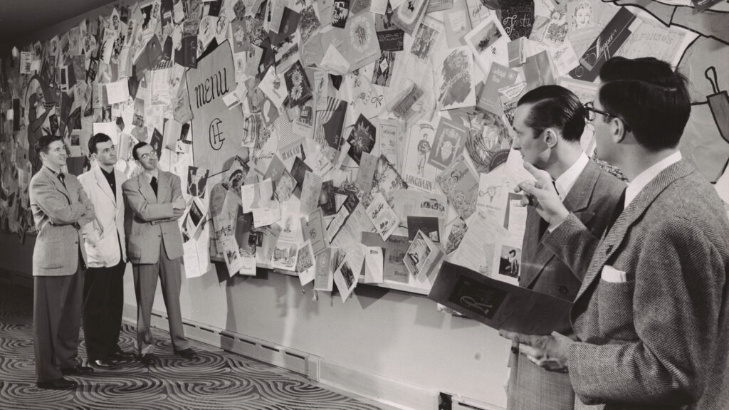 In 1951, attendees at Hotel Ezra Cornell view a wall of menus from establishments founded or run by alumni