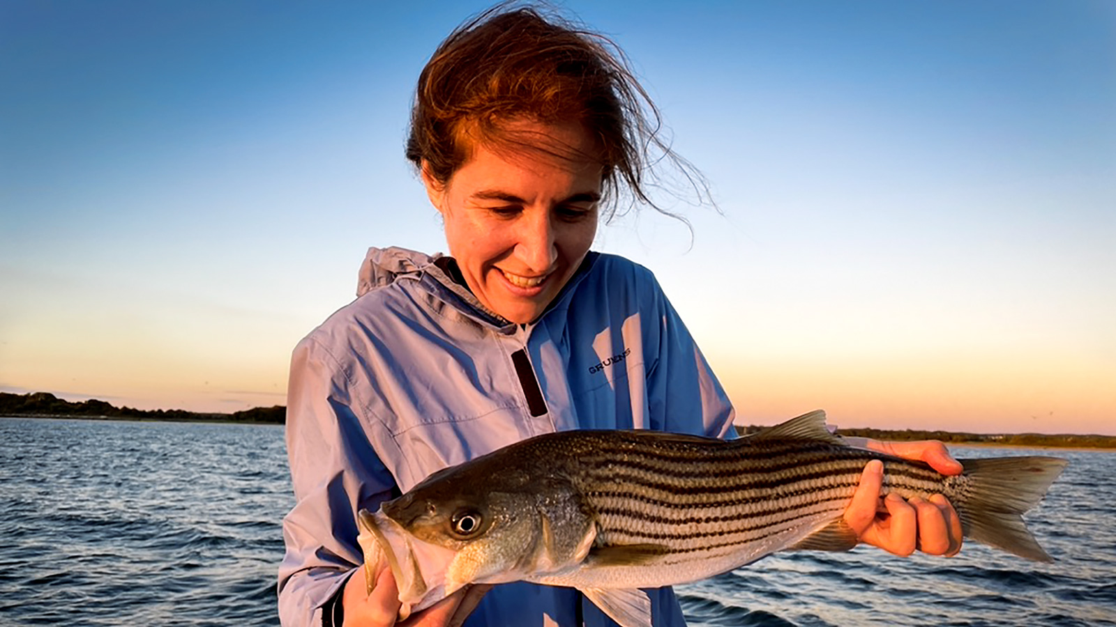 Katherine Bemis with a striped bass she caught while fishing in New England in 2024