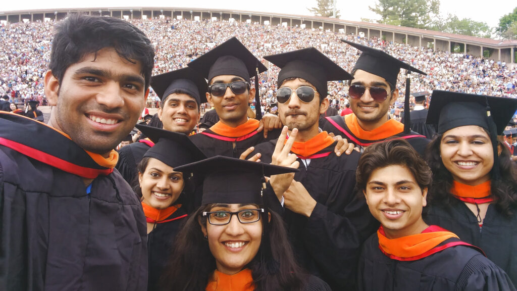 Saurabh Netravalkar posing for a selfie at commencement with friends in their regalia.