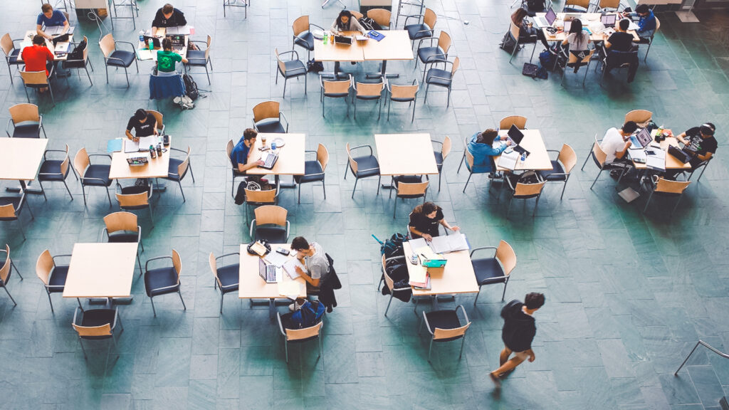 An overhead view of students sitting at tables in Duffield Hall studying for exams