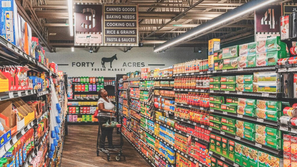 An aisle inside Forty Acres Fresh Market that has canned books, pastas, and rice stacked in the shelves.