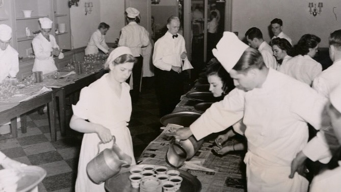 beverages are prepped on trays in a kitchen during an early Hotel Ezra Cornell