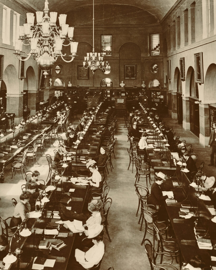 A black and white undated vintage photo of students sitting at tables studying in the University Library (Uris Library today)