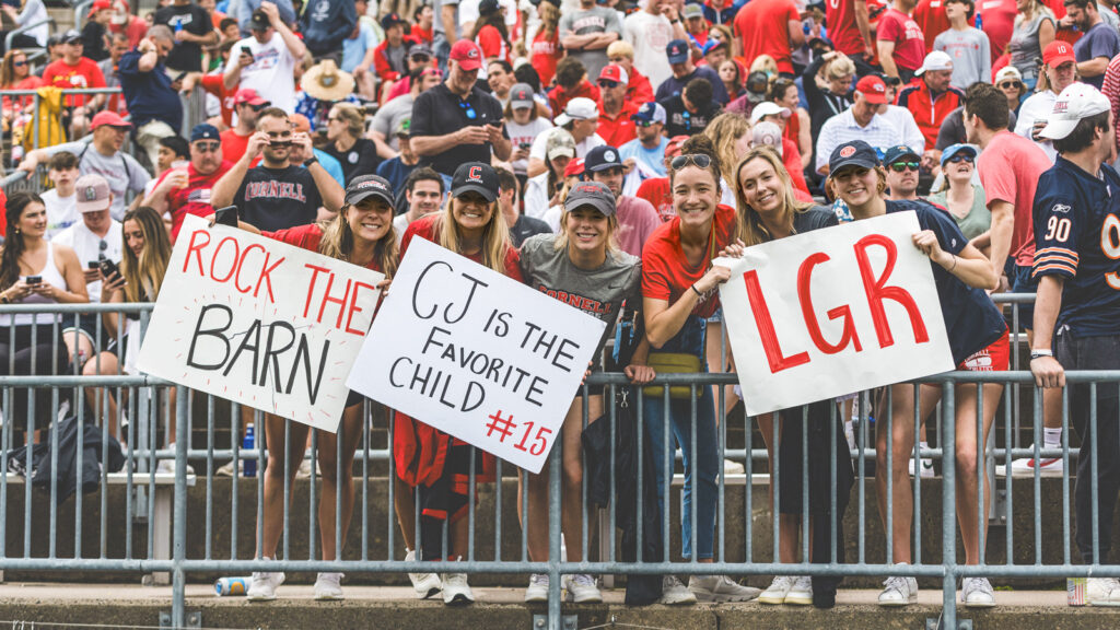 The Cornell Big Red men’s lacrosse team competes against Rutgers on Saturday, May 28, 2022 in East Hartford, CT during the NCAA National Semifinals. Fans are holding up signs that say "Rock the Barn," CJ is the favorite child #15," and LGR"
