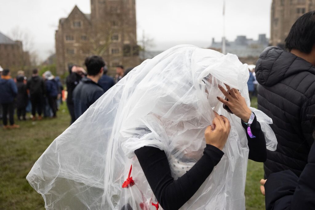 A student covered in clear garbage bags to keep out the rain