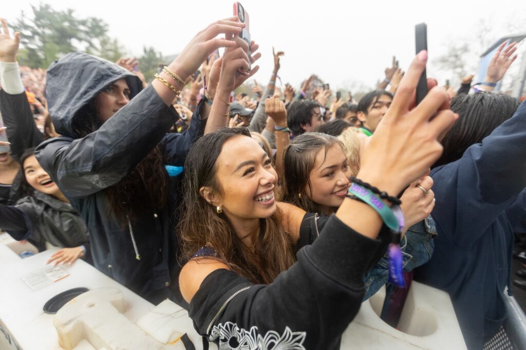 Students in the crowd take cell phone photos on Slope Day
