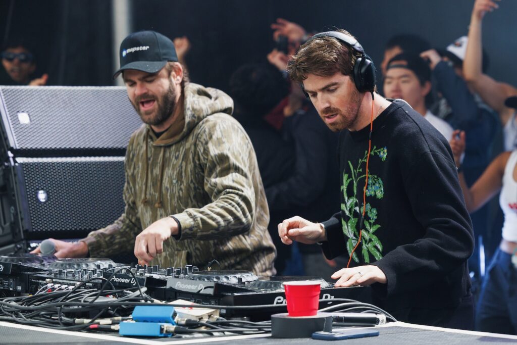 Two male performers at a sound board during Slope Day