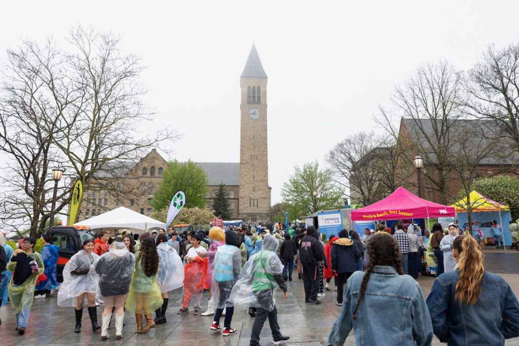 Students, some in rain gear, on Ho Plaza during the Slope Day festival
