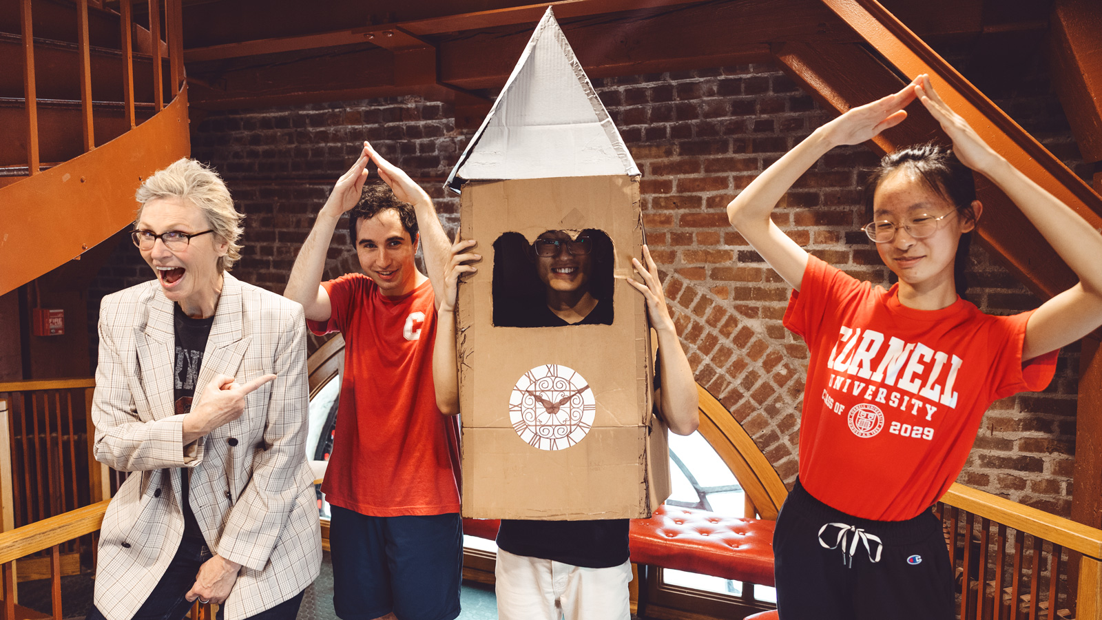 Jane Lynch tours McGraw Tower with Chimesmasters. One is wearing a cardboard tower costume