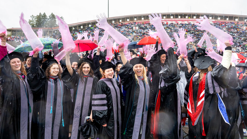 DVM grads wave large pink inflated exam gloves