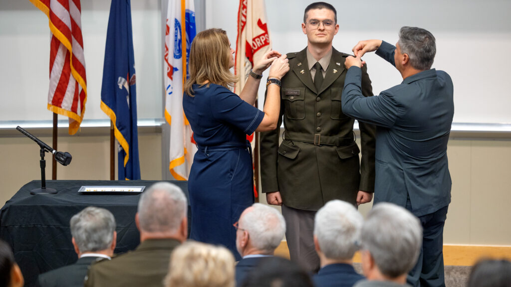 A young man in an Army uniform has insignia pinned on both epaulets