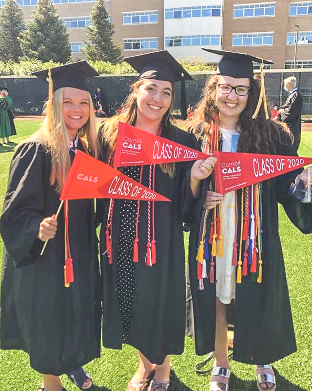 Lara Patz (center) in cap and gown with friends at commencement