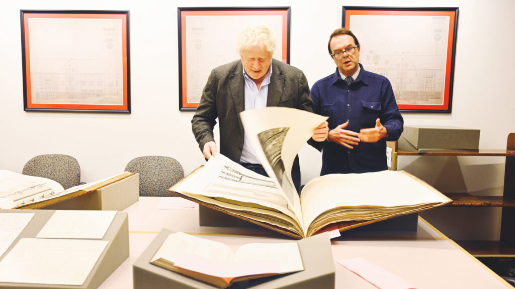 Boris jJohnson looks through a book in the Kroch Library reading room with curator Laurent Ferri