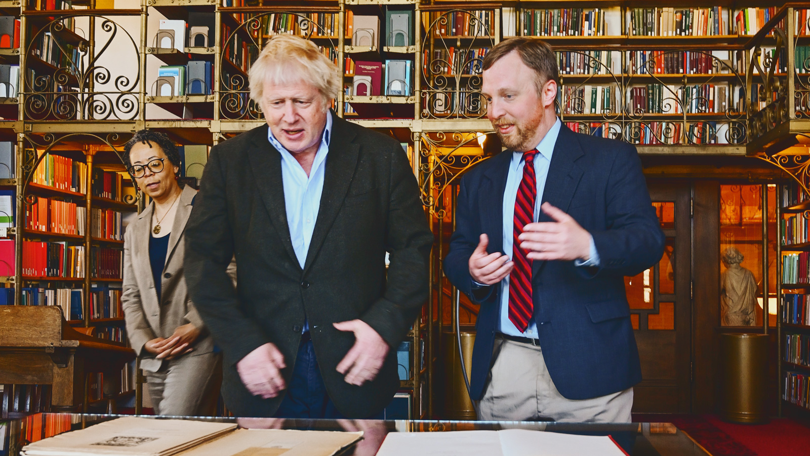 Boris Johnson in AD White reading room with Corey Earle, as University Librarian Elaine Westbrooks looks on