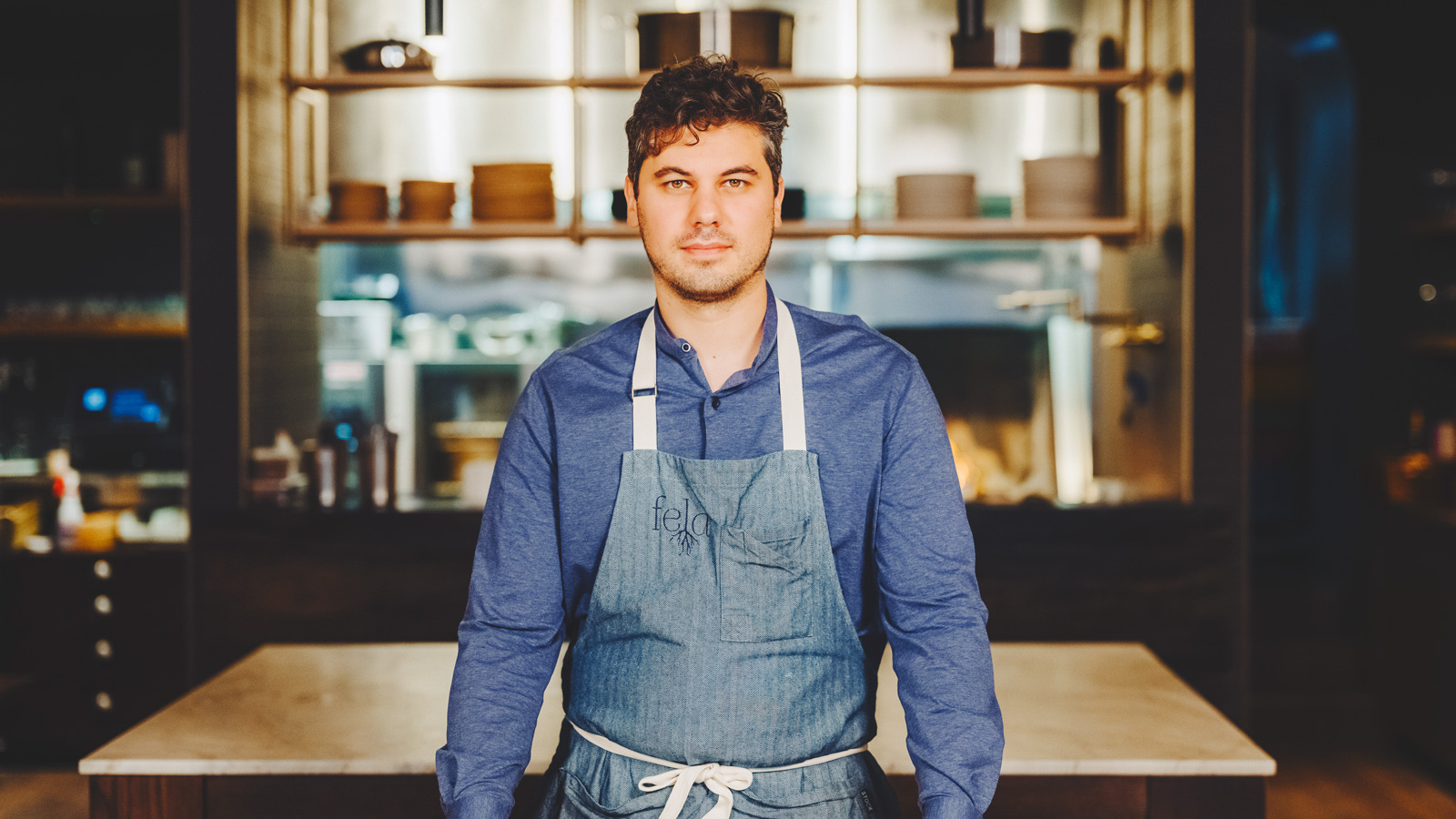 Jake Potashnick in a Feld apron standing in the dining room.