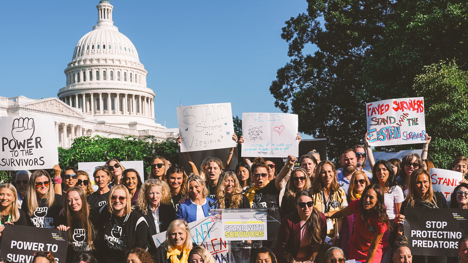 Rachel Foster and a group of women from World Without Exploitation celebrate and hold posters in the air in front of the Capitol after learning the Epstein Files Transparency Act was just passed by the Senate.