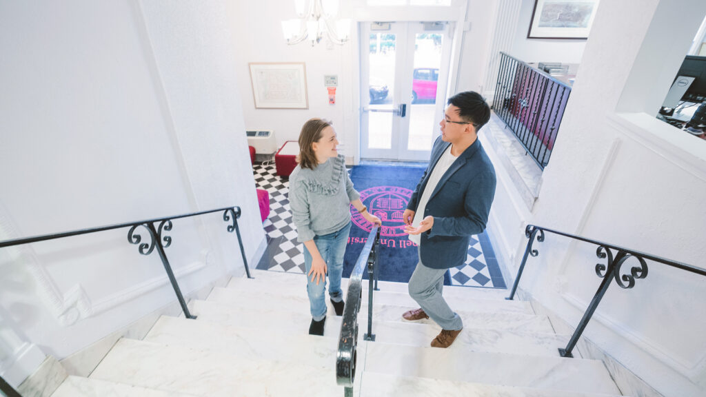 two students chat on the steps near the lobby of the Cornell in Washington headquarters, the Wolpe Center, in 2019