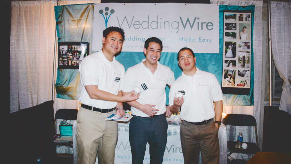 Tim Chi, center, and two other WeddingWire co-founders at their first conference booth at an event