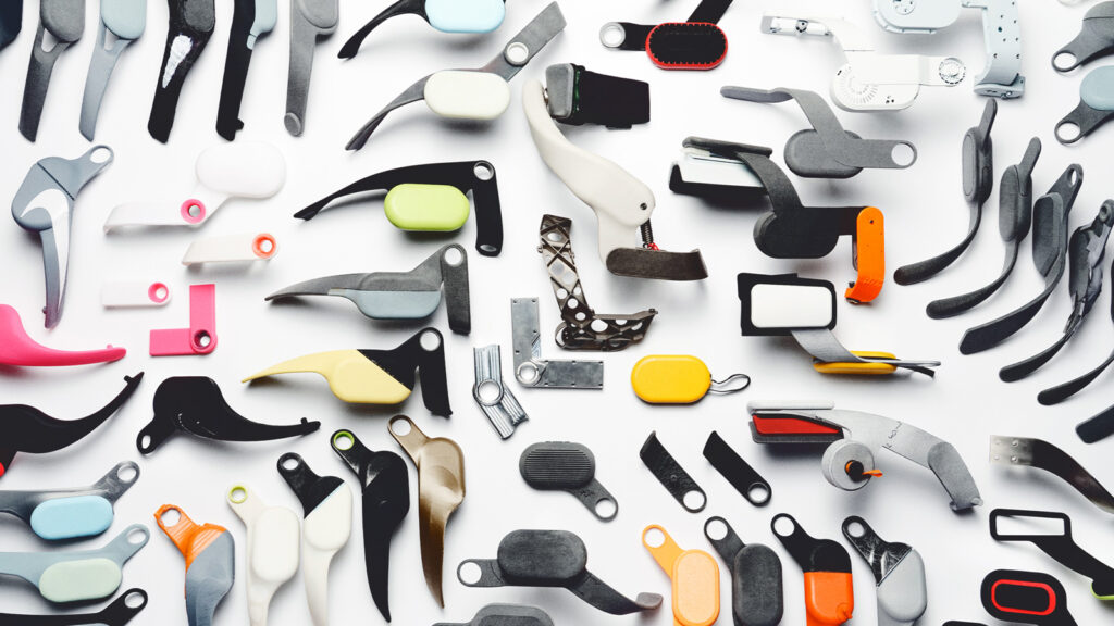 Dozens of different pieces of Project Amplify in different colors, including the battery, motor, and frame, on a white background.