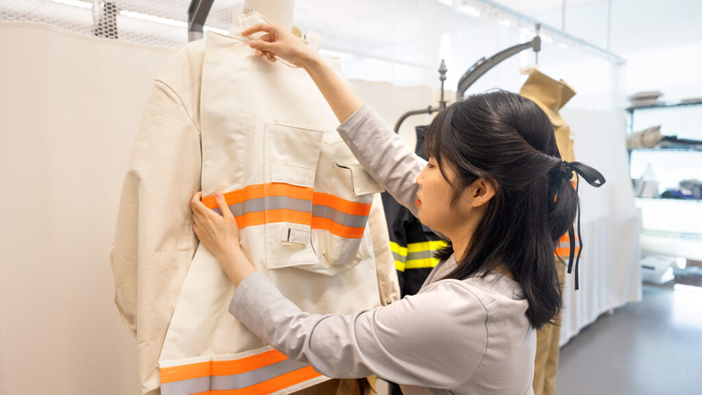 Doctoral student Huieun Do, MA ’25, examines a white firefighter coat