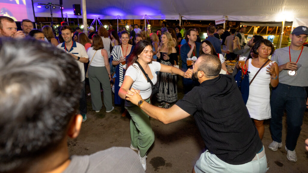Two alumni dance together during a tent party on the Arts Quad during Reunion 2026