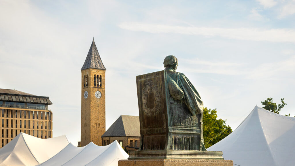 The top of the tents on the Arts Quad and the Andrew Dickson White statue are visible with Olin Library and McGraw Tower in the background during Reunion 2026