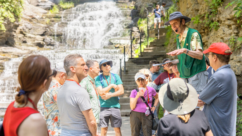 A group listens to a tour guide while standing on the Cascadilla Gorge Trail during Reunion 2026
