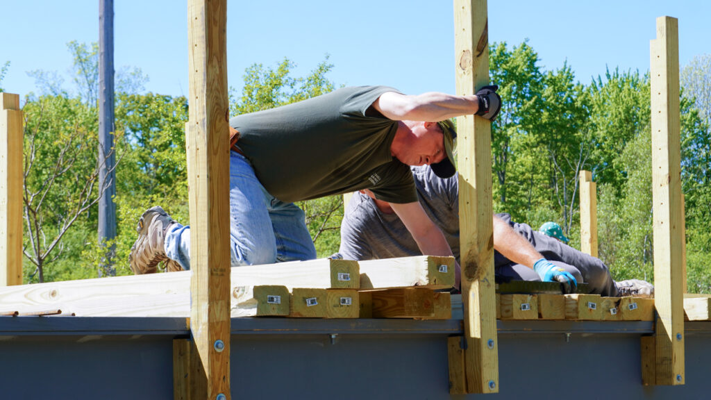 Todd Bittner, director of natural areas for Cornell Botanic Gardens, installs decking on the Dryden Rail Trail bridge