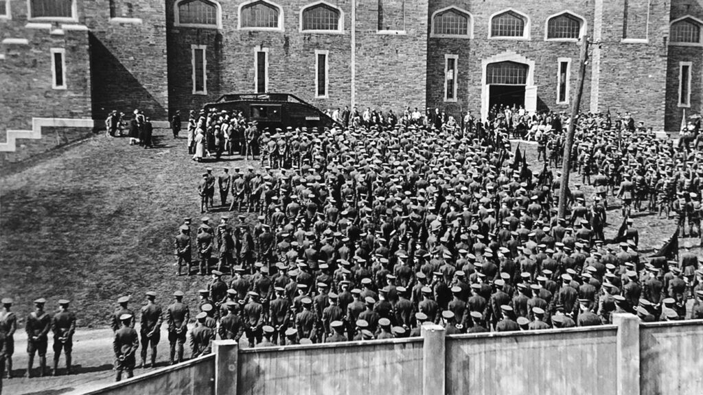 A crowd of men in uniform watch as Cornell receives the gift of a 29-ton, World War I tank. (May 14, 1926 )