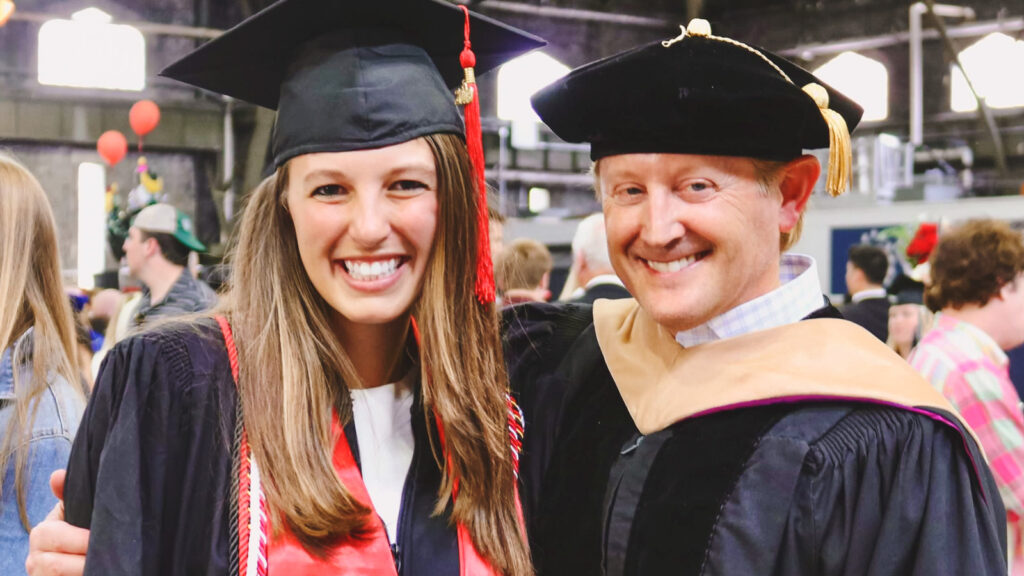 Amanda Friedman at commencement in her regalia with Professor Bruce Tracey.