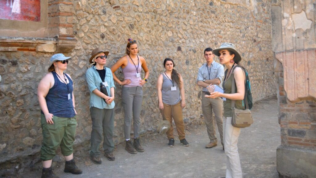 Caitlín Barrett, right, takes the Casa della Regina Carolina Project group on a tour of Pompeii.