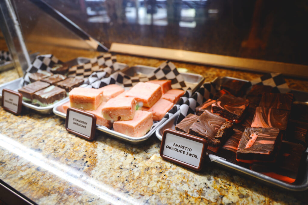 Fresh fudge on display in the flavors amaretto chocolate swirl and strawberry cheesecake.