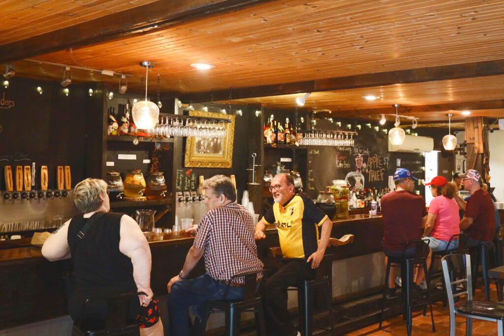 Guests sit at the bar and talk to each other inside the brewpub at Becker Farms.