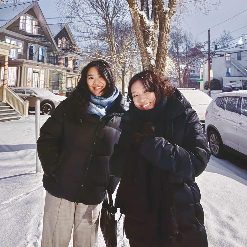Serin Koh and a friend wearing black parkas in Collegetown after a blizzard