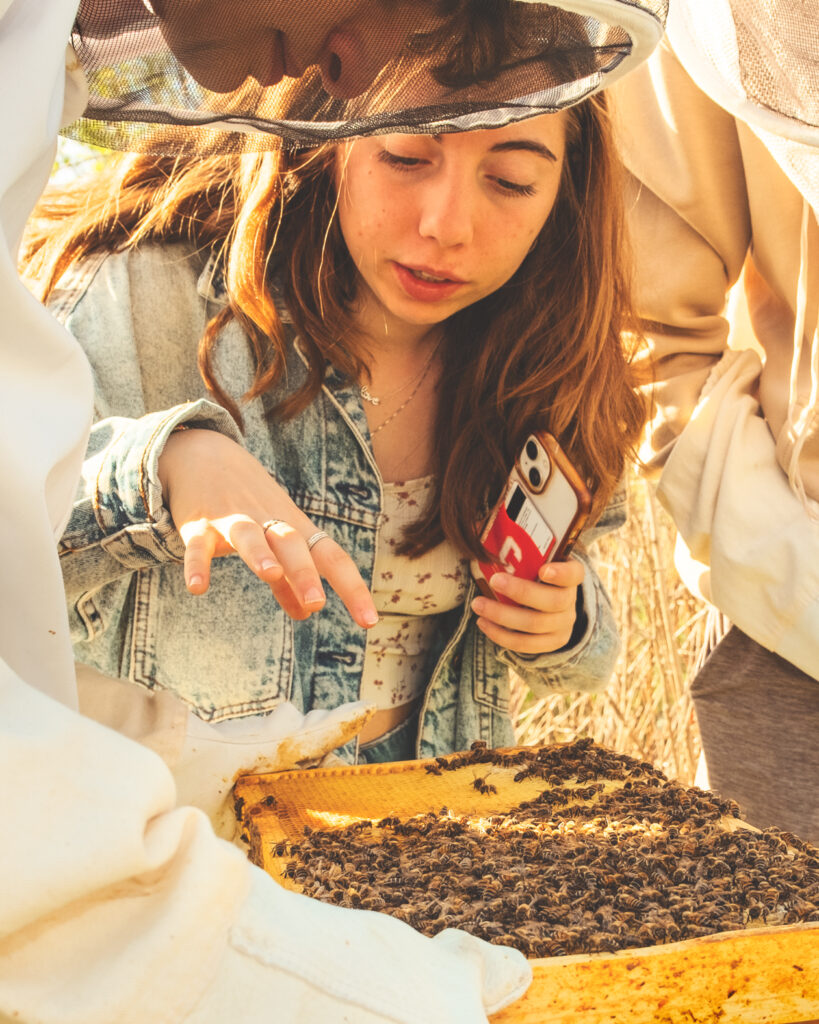 Jocelyn Nashtatik takes a close look at some of the bees during a hive inspection in May