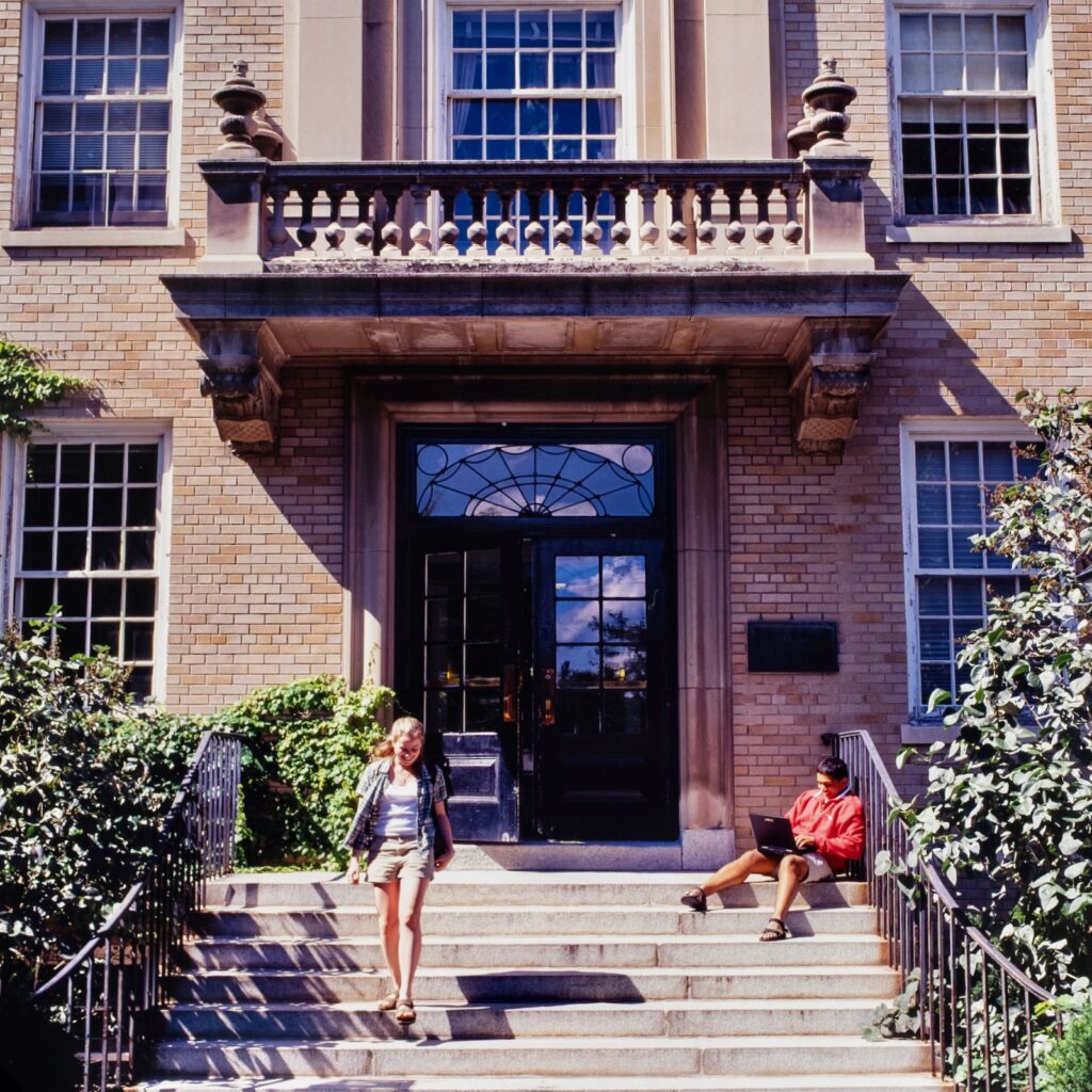 students on the steps of a campus building in a vintage undated color photo