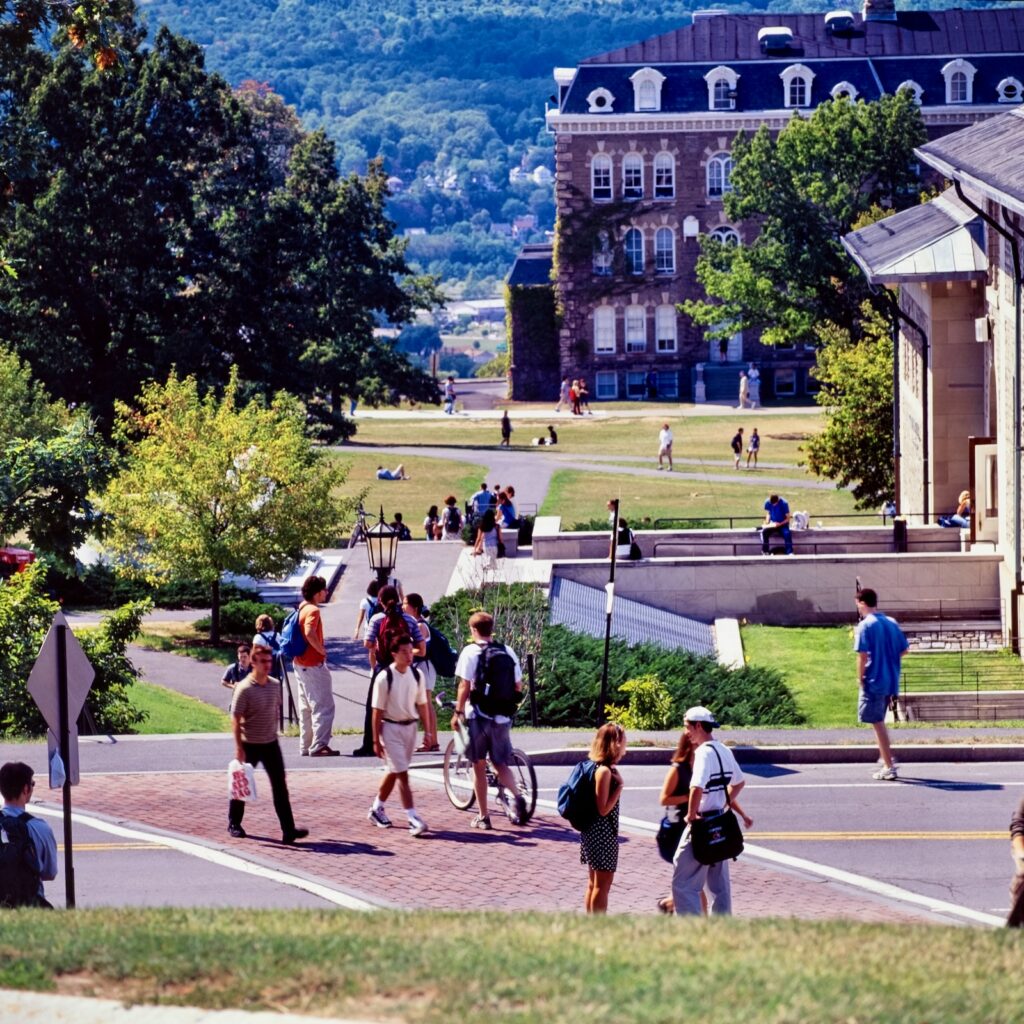 photo of students crossing East Avenue on campus in the 1990s with the Arts Quad visible in the distance