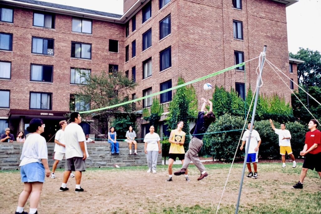 students play volleyball outside Sperry Hall on West Campus in the 1990s