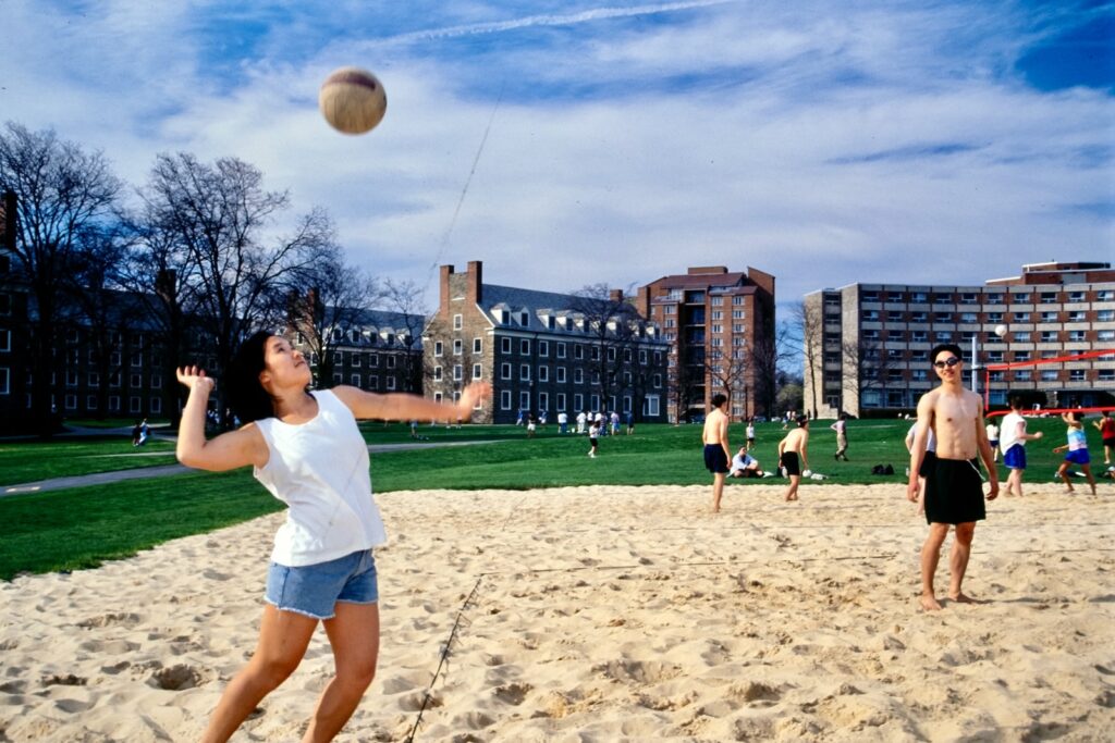 students play beach volleyball on North Campus in a vintage color image from the 1990s