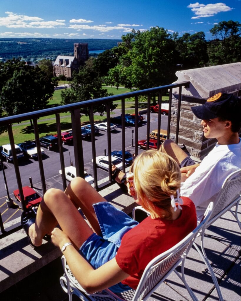 two students take in the view of West Campus and Cayuga Lake from the Ivy Terrace at Willard Straight Hall in a vintage image from the 1990s