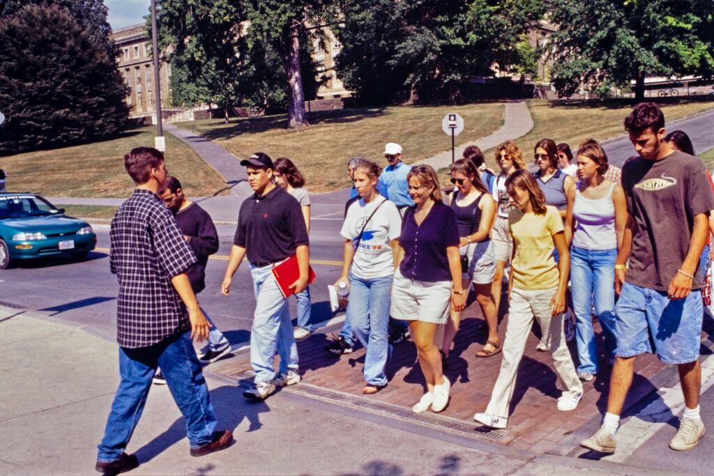 a tour group crosses East Avenue on campus in 1998