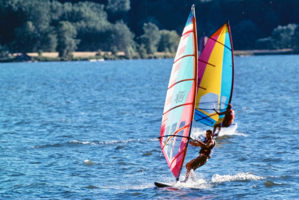 boaters ride sailboards on Cayuga Lake in a vintage color image from 1998