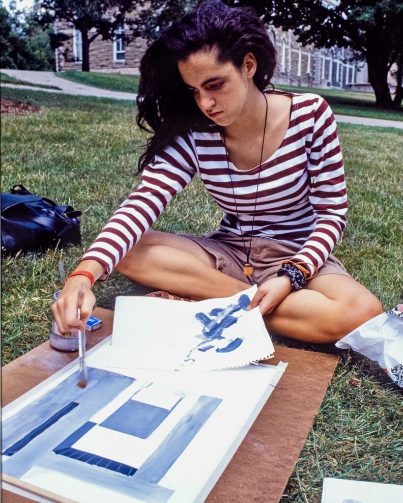 a student paints on the Arts Quad in 1990