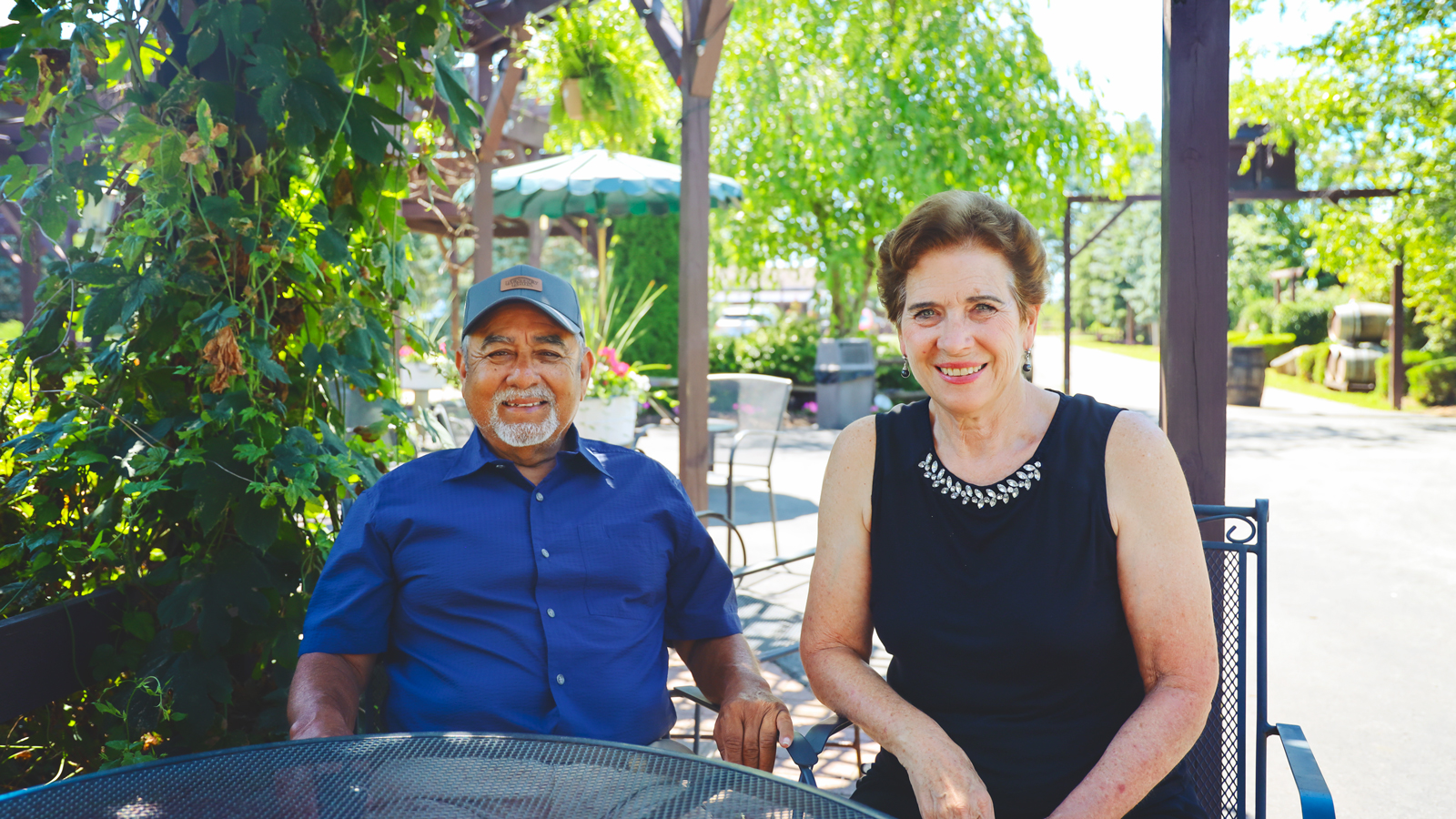 Melinda and Oscar Vizcarra sit next to each other and smile while sitting at a table at Becker Farms in July 2026.