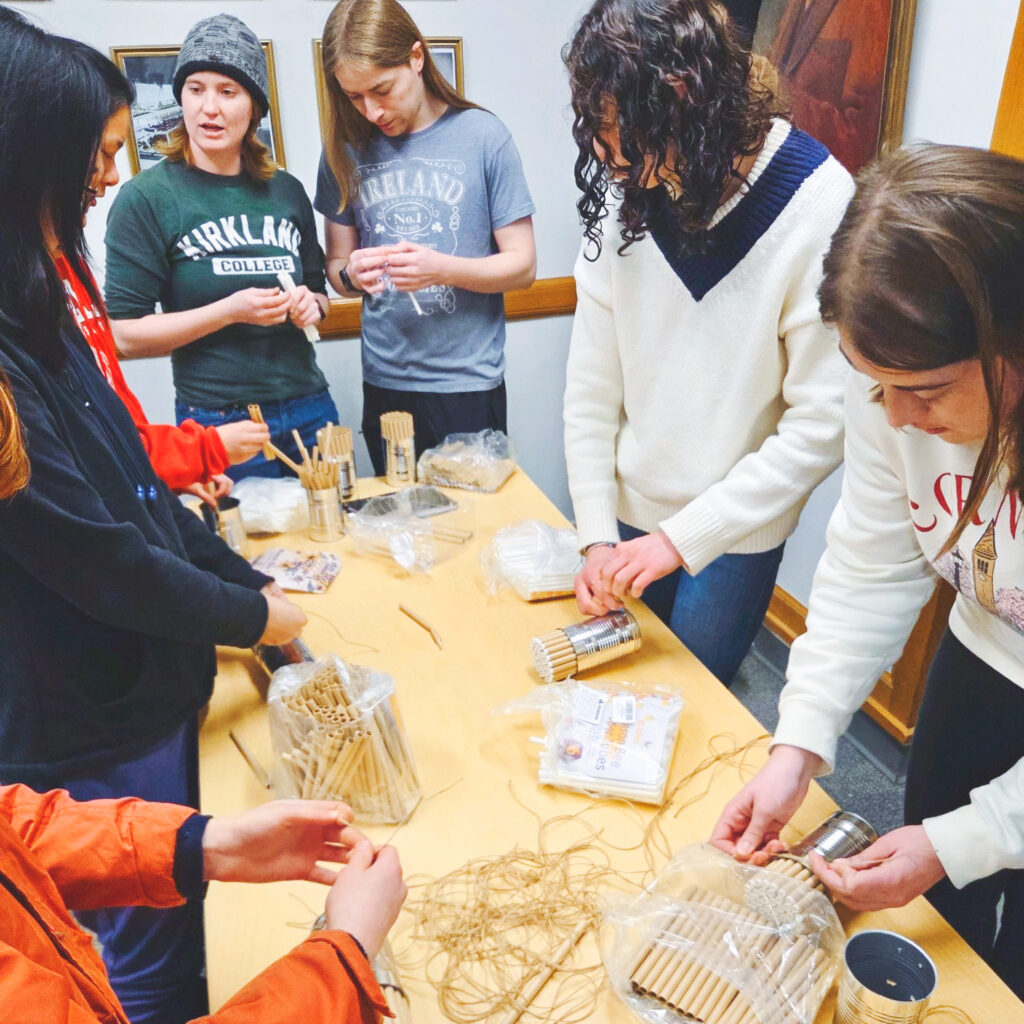 members of the Bee Club at Cornell make crafts using beeswax at an event
