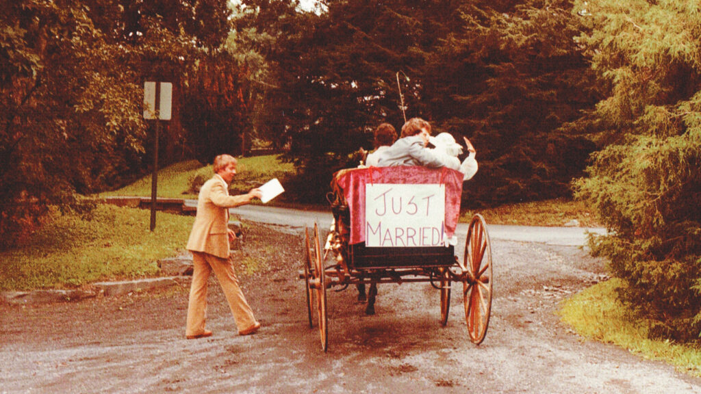 Pam Lein ’81 & Rick Meigs ’80 depart their wedding ceremony in a carriage that says 'Just Married' on the back