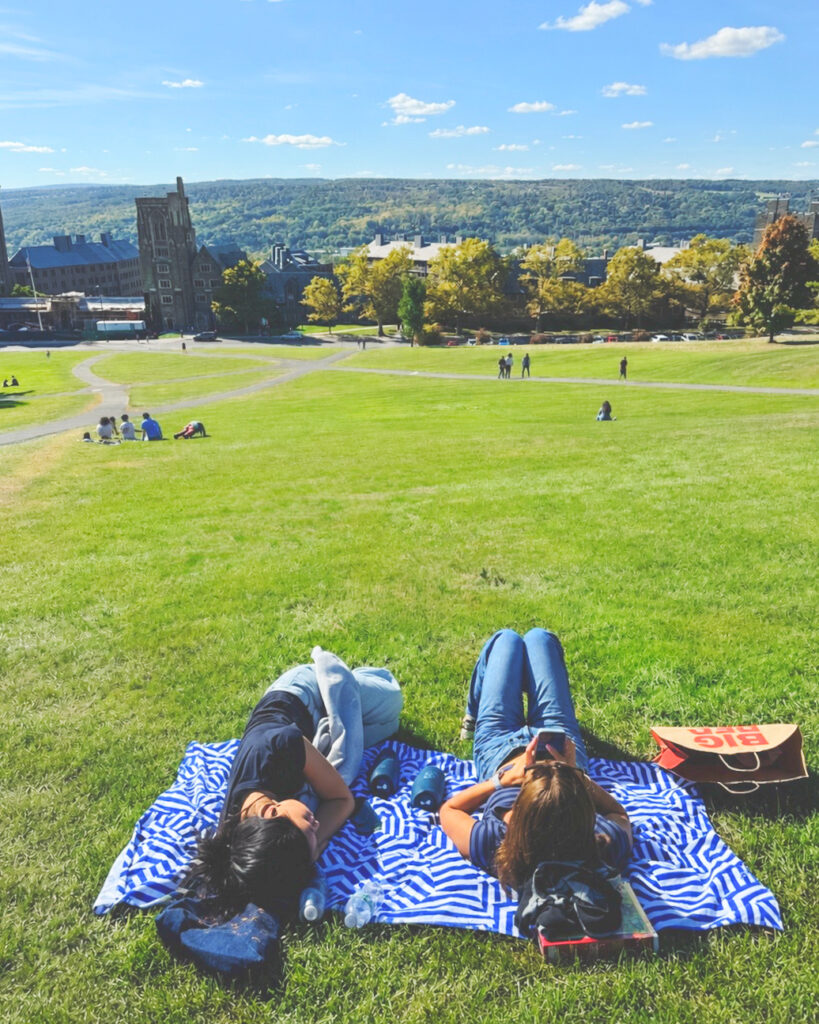 Serin Koh and a friend lying on a blanket on the Slope on a sunny day