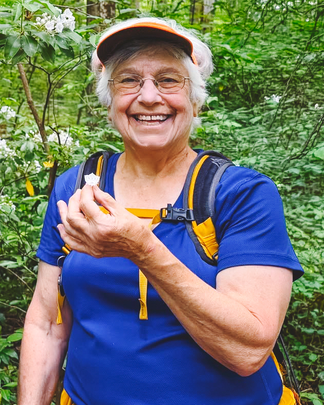Myra Shulman on a hike, holding a mountain laurel blossom